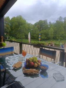 a table with a plate of fruit and crackers on it at PAMJA Guest House in Bărăşti