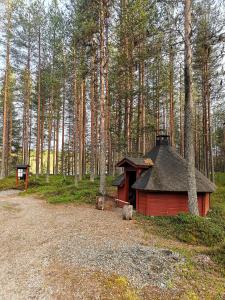 a small red cabin in the middle of a forest at Hossa Teeriranta in Teeriranta