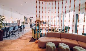a lobby with a couch and chairs and a bar at Hilton Garden Inn Manchester Emirates Old Trafford in Manchester