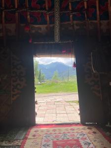 an open door with a view of a mountain at Ak-Suu Eco House in Teploklyuchinskoye