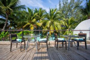 a table and chairs on a deck with palm trees at Crown Regency Beach Resort in Boracay