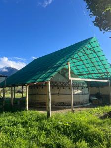 a tent with a green roof on a field at Ak-Suu Eco House in Teploklyuchinskoye