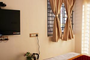 a living room with a television and a window at Altiora Homestay in Kodaikānāl +82 photos