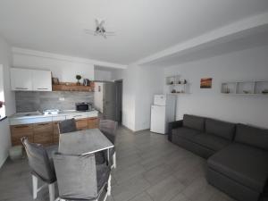 a kitchen and a living room with a couch and a table at Vila La Fernando in Tuzla