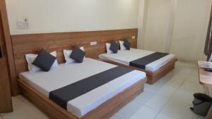 two beds in a hotel room with sidx sidx sidx sidx at Hotel Gokul in Ujjain