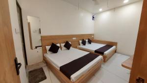 a bedroom with two beds in a room at Hotel Gokul in Ujjain