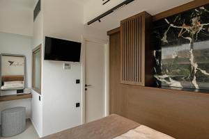 a bedroom with a bed and a tv on a wall at IzaVera Luxury Suites - Vera in Heraklio