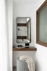 a mirror on a shelf in a room with a stool at IzaVera Luxury Suites - Vera in Heraklio +30 photos