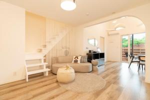a living room with a couch and a staircase at 軽井沢一棟貸しBBQサウナつき別荘- YURAGI - TSUKI me CHILL in Miyota +192 photos