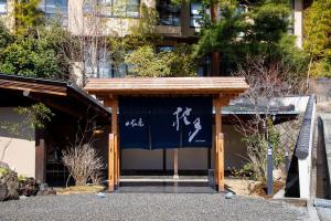 a building with a blue and white banner on it at 日長庵 桂月 in Hirugami