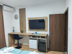 a room with a desk with a television on a wall at Vila Vanila in Gevgelija