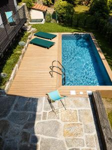 a swimming pool with a wooden deck and chairs at Il Lavatoio in Cissano
