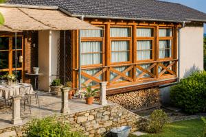 a house with wooden doors and a table on a patio at Corte Villa Donati in Cissano