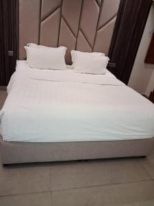 a large bed with white sheets and pillows at Rose Beach 4 Durrat Alarous in Durat Alarous +20 photos