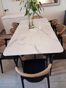 a white marble table with chairs and a plant on it at Rose Beach 4 Durrat Alarous in Durat Alarous