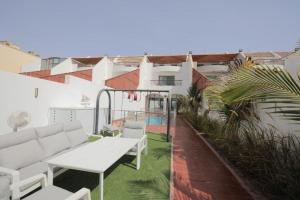 a patio with a couch and a table on a balcony at Rose Beach 4 Durrat Alarous in Durat Alarous