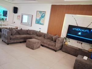 a living room with a couch and a flat screen tv at Rose Beach 4 Durrat Alarous in Durat Alarous