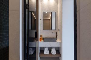 a bathroom with a sink and a mirror at IzaVera Luxury Suites - Vera in Heraklio