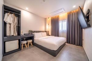 a hotel room with a bed and a television at Giverny Hotel in Gyeongju