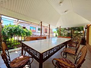 a dining table and chairs on a patio at Вілла з 6 Спальнями Басейн Більярд Сауна BBQ Укриття in Odesa