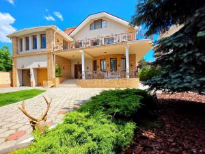 a large house with a porch and a driveway at Вілла з 6 Спальнями Басейн Більярд Сауна BBQ Укриття in Odesa