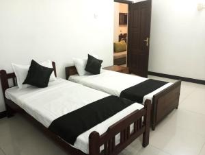 two beds sitting next to each other in a room at Ceylander Suites in Kandy