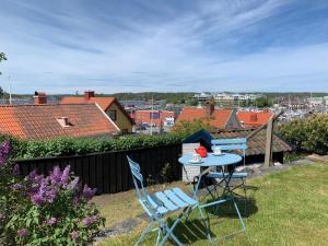 a table and chairs on a backyard with a view of a city at Stuga med havsutsikt in Strömstad