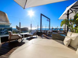 a balcony with chairs and tables and a view of the ocean at Sofitel Barcelona Skipper in Barcelona