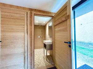 a bathroom with a sink next to a door at Paradis d'Ubaye - Terrasse - Plan d'eau - Jardin in Jausiers