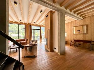 a living room with wood paneling and a piano at Paradis d'Ubaye - Terrasse - Plan d'eau - Jardin in Jausiers +68 photos