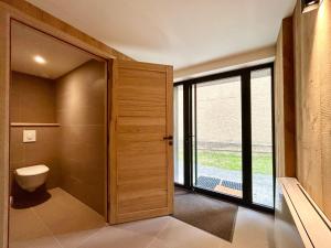 a bathroom with a toilet and a large window at Paradis d'Ubaye - Terrasse - Plan d'eau - Jardin in Jausiers