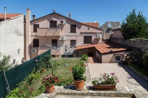 a house with potted plants in a yard at Marea in Veli Lošinj