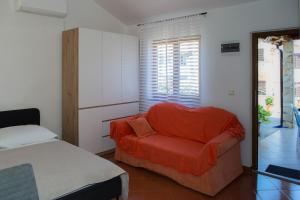 a bedroom with a bed and a red chair at Marea in Veli Lošinj