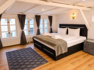 a bedroom with a large bed and windows at Wismar Apartments - Cozy and Central in Wismar