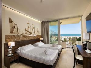 a hotel room with two beds and a balcony at Mercure Rimini Lungomare in Rimini +101 photos