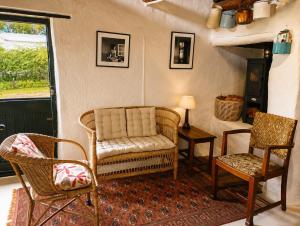 a living room with a chair and two chairs at Old Corner Cottage in McGregor
