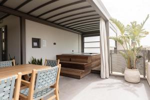 a room with a wooden table and a bath tub at IzaVera Luxury Suites - Vera in Heraklio