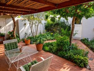 an outdoor patio with a table and chairs and plants at Old Corner Cottage in McGregor