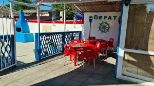 a red table and chairs on a patio at Casa Epat in 2 Mai