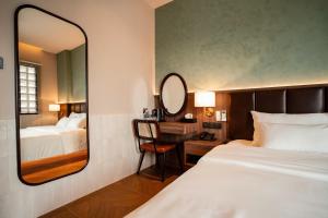 a bedroom with a mirror and a bed and a desk at Nhiên Hotel in Ho Chi Minh City