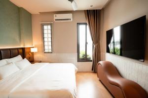 a bedroom with a bed and a flat screen tv at Nhiên Hotel in Ho Chi Minh City