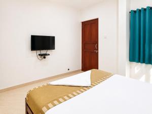 a bedroom with a bed and a tv on the wall at Goa Villagio Hideaway in Majorda