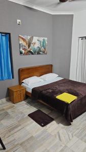 a bedroom with a large bed with a wooden headboard at Easystayhomestay in Kunnamangalam