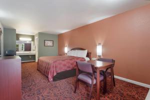 a hotel room with a bed and a table and chairs at Econo Lodge Thomaston in Thomaston +18 photos