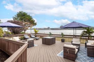a deck with chairs and tables and umbrellas at Comfort Inn Edgewater on Hudson River in Edgewater