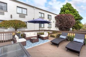 an outdoor patio with chairs and an umbrella at Comfort Inn Edgewater on Hudson River in Edgewater