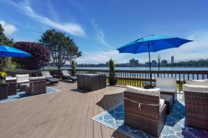 a patio with chairs and umbrellas on a wooden deck at Comfort Inn Edgewater on Hudson River in Edgewater