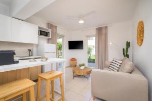 eine Küche und ein Wohnzimmer mit Sofa und Tisch in der Unterkunft Einalia Holiday Homes in (( Elaiónas ))