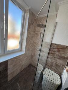 a bathroom with a shower with a glass door at Apartman Tuzla in Tuzla +7 photos