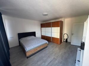 a bedroom with a bed and a wooden cabinet at Apartman Tuzla in Tuzla